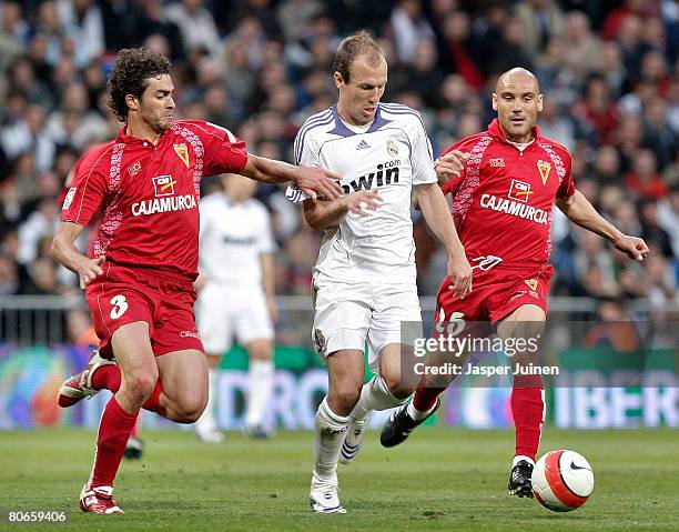 Arjen Robben of Real Madrid duels for the ball with Alejandro Maranon and Jose Maria Movilla of Murcia during the La Liga match between Real Madrid...