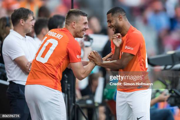 Lukas Podolski of Nowitzki All Stars jokes with Serge Gnabry during the Champions for Charity Friendly match at Opel Arena on July 3, 2017 in Mainz,...