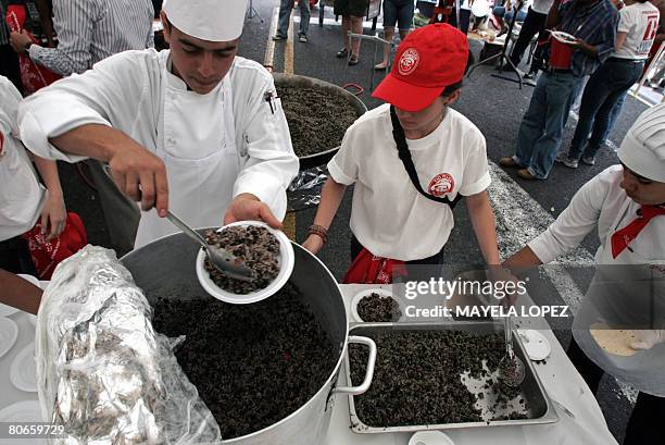 Chef serves a plate of "Gallo Pinto" -typical dish made of rice and beans- on April 13 in one of the main streets of San Jose during the first Gallo...