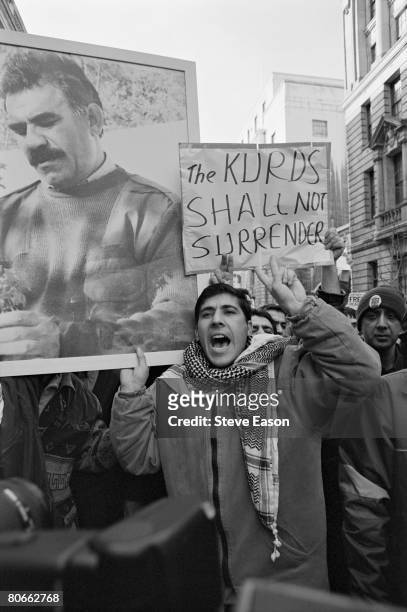Kurdish demonstrators hold a portrait of Kurdistan Workers Party leader Abdullah Ocalan, as well as a placard reading 'The Kurds Shall Not...