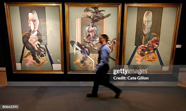 Sotheby's employee passes in front of Francis Bacon's triptych on April 14, 2008 in London, England. The artwork, estimated to sell for 70 million...