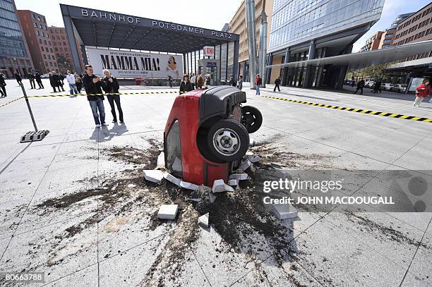 Sculpture simulates a car crashed in the pavement on Berlin's Potsdamer Platz April 14, 2008. The sculpture is a publicity stunt for a German...