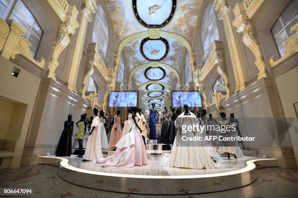 Dresses are pictured during the Dior exhibition that celebrates the seventieth anniversary of the Christian Dior fashion house on July 3, 2017 in...