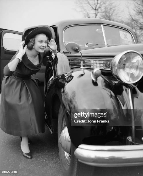 Teenage debutante Anthea Found checks her appearance in a car wing mirror before attending a Presentation Party at Buckingham Palace, London, 18th...