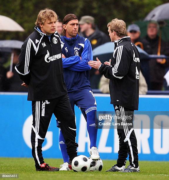 New coaches Youri Mulder and Mike Bueskens speak with Marcelo Bordon during a FC Schalke 04 training session at the Veltins Arena on April 14, 2008...