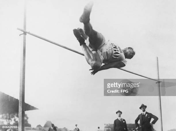 American athlete Harold Osborn clearing the high jump using the 'western roll' style at the Paris Olympics, 1924. Osborne won the Olympic gold in the...