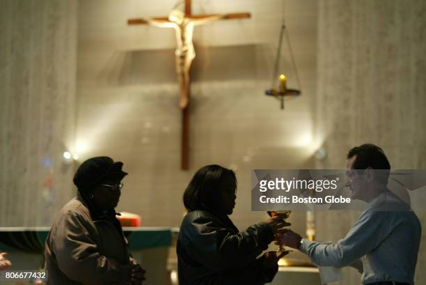 Carl Croteau serves the the wine during mass in Springfield, MA on Oct. 24, 2003. His son Danny was murdered in 1972. Father Richard Lavigne, a...