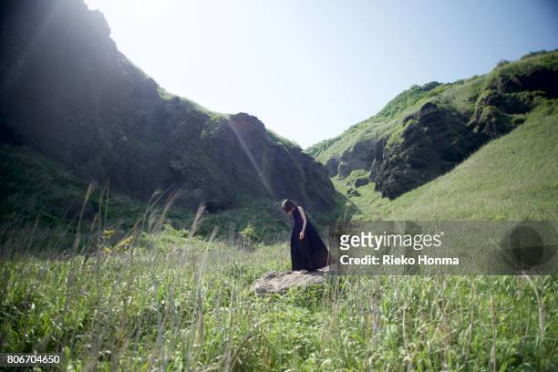woman standing in nature - rieko honma stock-fotos und bilder