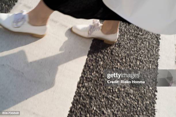 low section of woman walking on zebra crossing - japanese women feet stock pictures, royalty-free photos & images