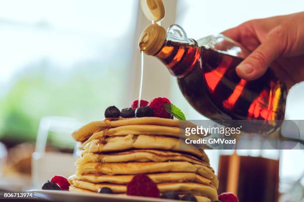 stapel pannenkoeken met ahornsiroop en verse bessen - maple syrup pancakes stockfoto's en -beelden