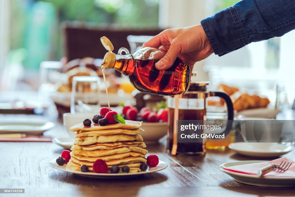 Stack of Pancakes with Maple Syrup, Berries and Fresh Coffee