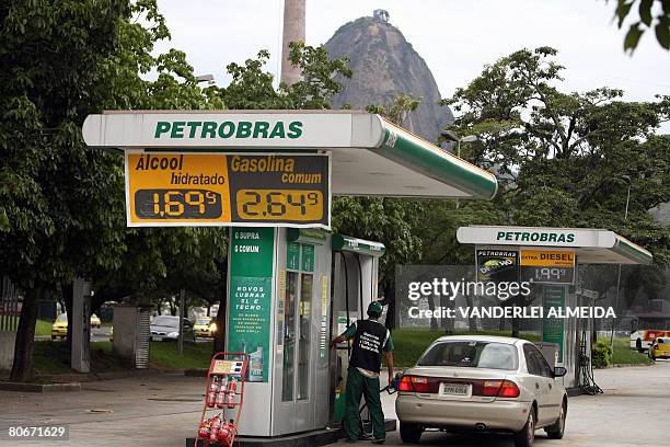 Car is refueled at a Petrobras petrol station with the Sugar Loaf hill in the background on April 14, 2008 in Rio de Janeiro, Brazil. Brazilian Oil...