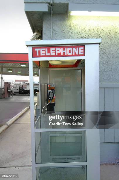 Side view of an empty telephone booth on the side of a gas station, USA, mid-1990s.
