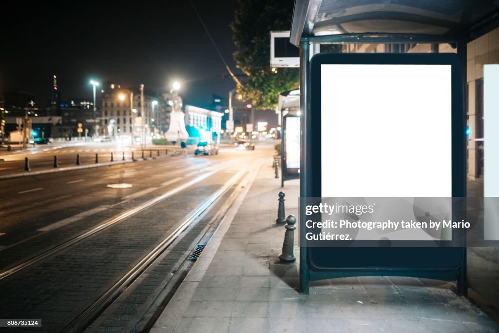 Bus stop with billboard at night