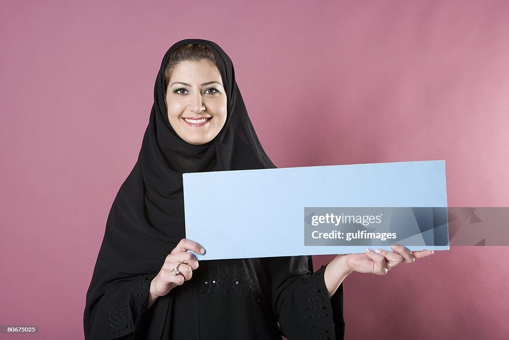 Young woman holding blank placard