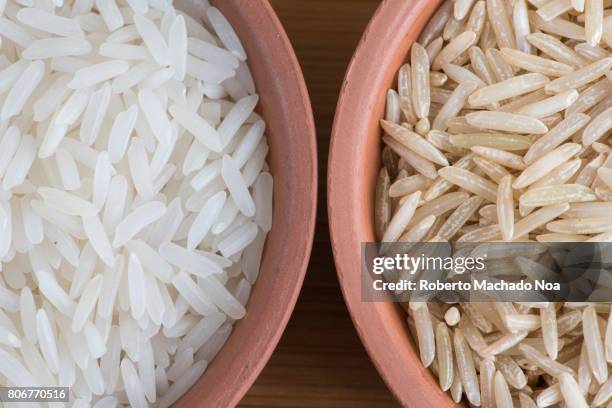 rice grains, cereal. brown rice compared to white rice. raw food close up - naturreis stock-fotos und bilder