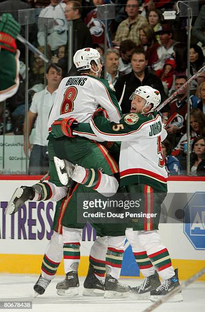Pierre-Marc Bouchard of the Minnesota Wild is mobbed by teammates Kim Johnsson and Brent Burns after Bouchard scored the game winning goal against...