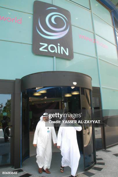 Two Kuwaiti men walk out of Kuwait's Mobile Telecommunications Co headquarters in Kuwait City on April 15, 2008. Zain launched the borderless "One...