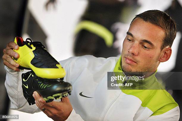 Dutch Wesley Sneijder of Real Madrid football team looks at new Nike soccer Boots during a promotional event for the Total 90 Laser II shoes in...