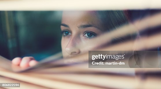 Unhappy woman looking through the window Unhappy woman looking through the window