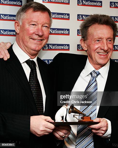 Manager of Manchester United, Sir Alex Ferguson presents former footballer Denis Law with his Lifetime Achievement Award during the HMV Football...