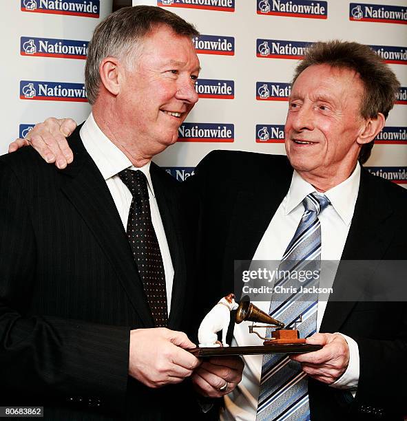 Manager of Manchester United, Sir Alex Ferguson presents former footballer Denis Law with his Lifetime Achievement Award during the HMV Football...