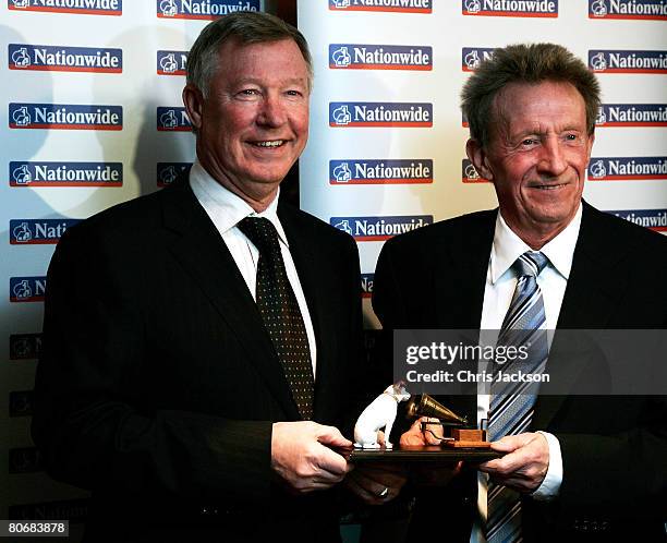 Manager of Manchester United, Sir Alex Ferguson presents former footballer Denis Law with his Lifetime Achievement Award during the HMV Football...