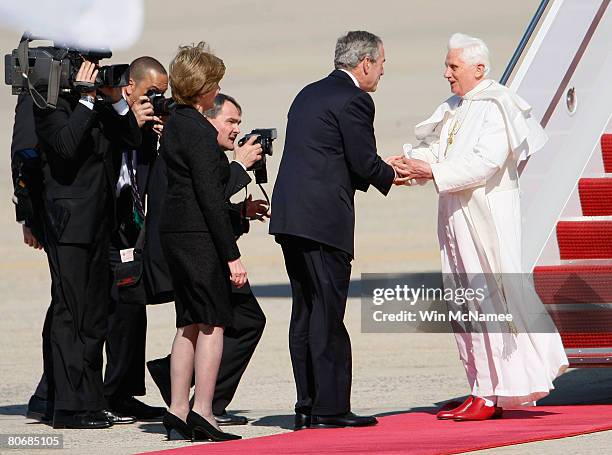 Pope Benedict XVI shakes hands with U.S. President George W. Bush as first Lady Laura Bush looks on, upon his arrival in the United States April 15,...