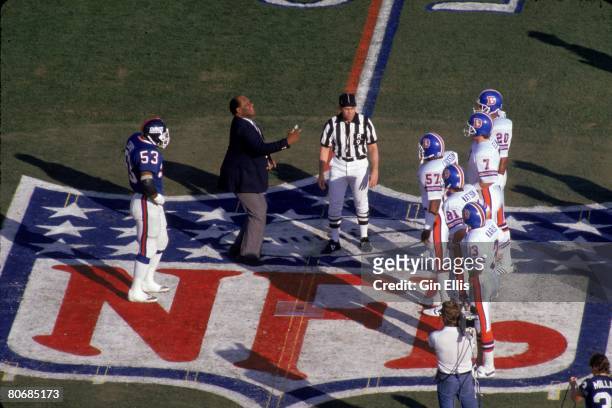 Former Green Bay Packers Hall of Fame defensive end Willie Davis flips the coin as linebacker Harry Carson of the New York Giants and kicker Rich...