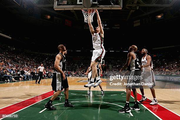 Andrew Bogut of the Milwaukee Bucks slam dunks over Ime Udoka and Bruce Bowen of the San Antonio Spurs during the game on March 1, 2008 at the...