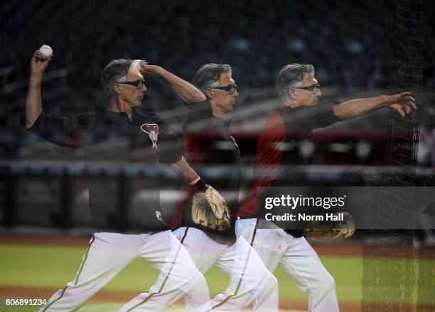 Multiple exposure of first base coach Dave McKay of the Arizona Diamondbacks throwing batting practice prior to a game against the Colorado Rockies...