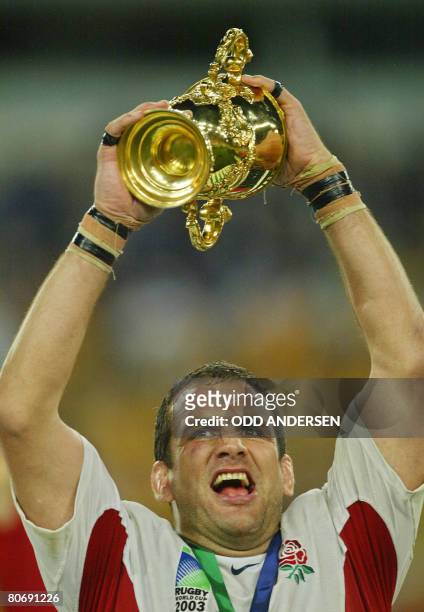 English rugby-union captain Martin Johnson holds the Webb Ellis Cup on the podium of the Rugby World Cup final at the Olympic Park Stadium in Sydney,...
