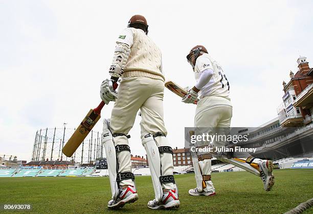 The opening batsmen for Surrey head out for the first innings of the season during day one of the LV County Championship Division One match between...