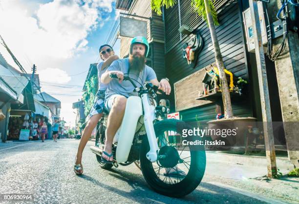happy couple - a bearded man and his handsome girlfriend - on a scooter at summer vacation - vintage motorcycle helmet stock pictures, royalty-free photos & images
