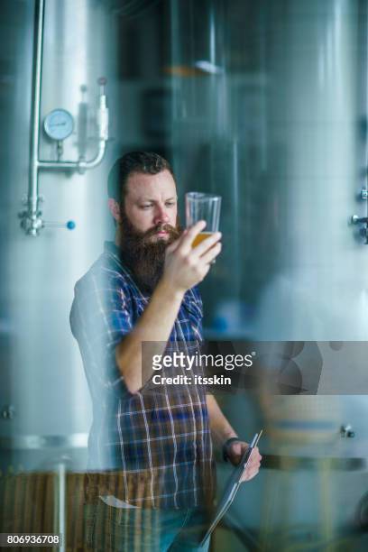 through the window: master works in the brewery: beer testing, making remarks, quality control - brewing stock pictures, royalty-free photos & images