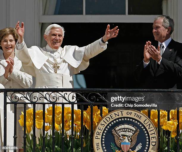 First lady Laura Bush and U.S. President George W. Bush applaud as Pope Benedict XVI waves to the crowd at the White House during an arrival ceremony...