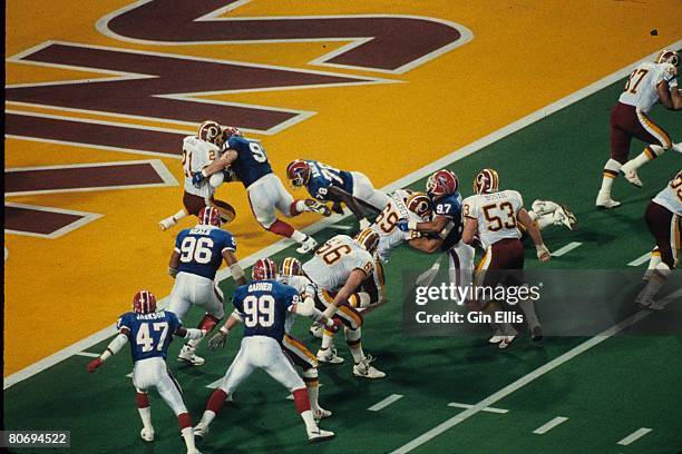 Running back Earnest Byner of the Washington Redskins tries to pull away from nose tackle Jeff Wright of the Buffalo Bills enroute to scoring a...