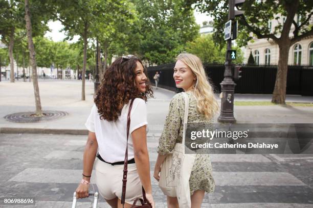 2 young women visiting paris - pantaloncini bianchi foto e immagini stock