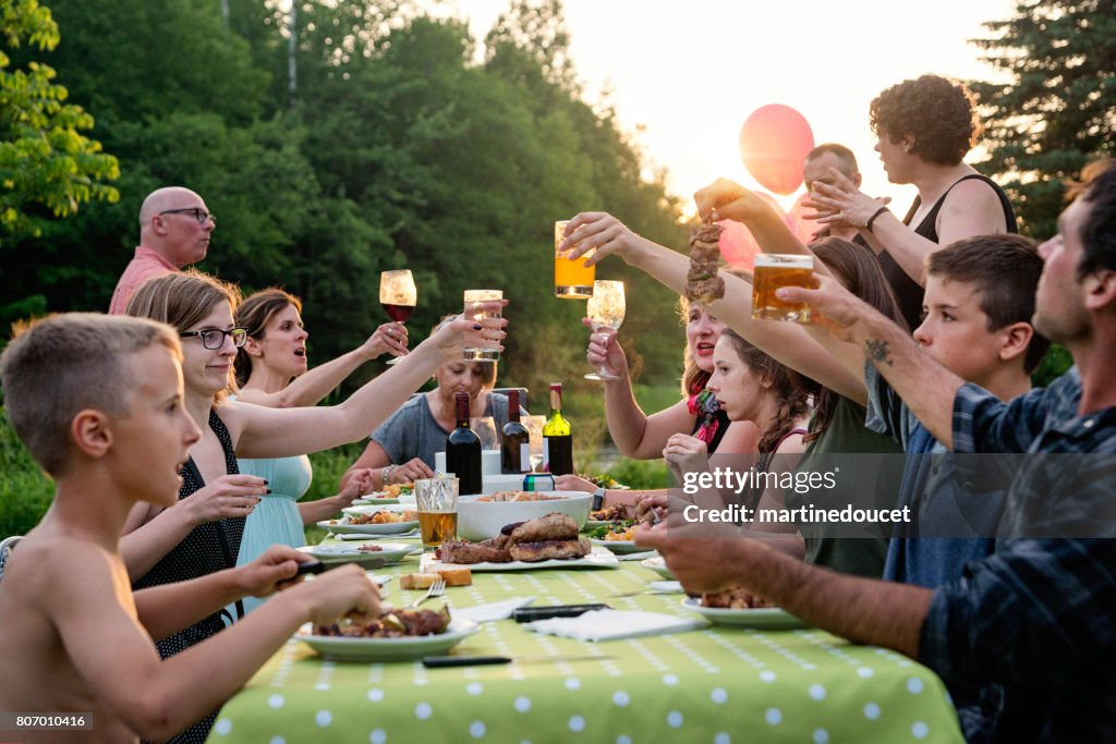 Grote familie barbecue verzamelen zonsondergang, zomer in de open lucht.