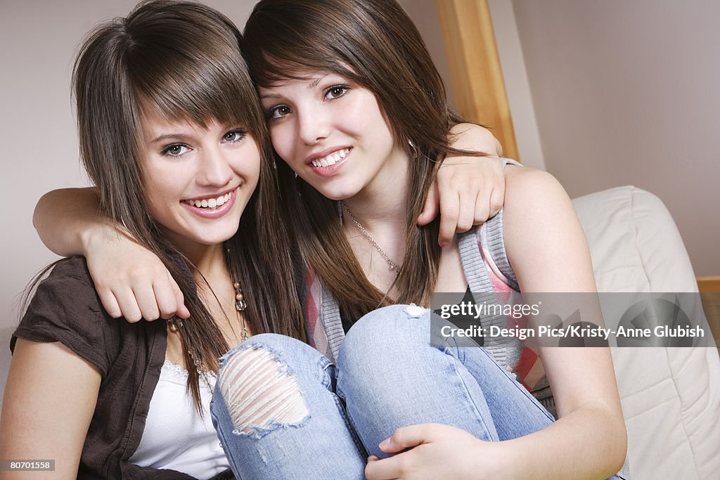 Two teen girls sitting in an embrace