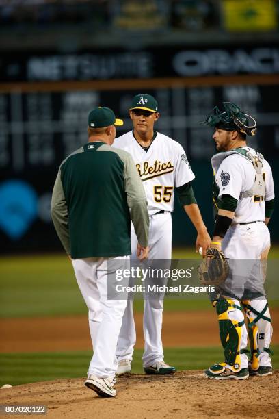 Pitching Coach Scott Emerson of the Oakland Athletics talks on the mound with Sean Manaea and Stephen Vogt during the game against the New York...