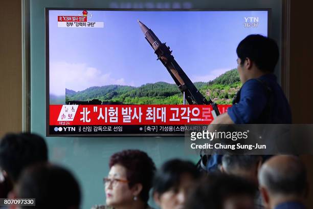 People watch a North Korea's KRT television show a photo of North Korea's test-launched first intercontinental ballistic missile released by Korean...