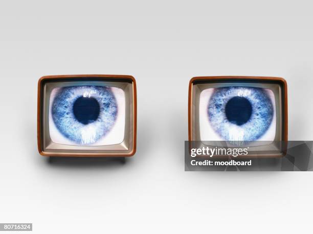 two old fashioned tv sets with blue eyes in studio shot - watching news stock pictures, royalty-free photos & images