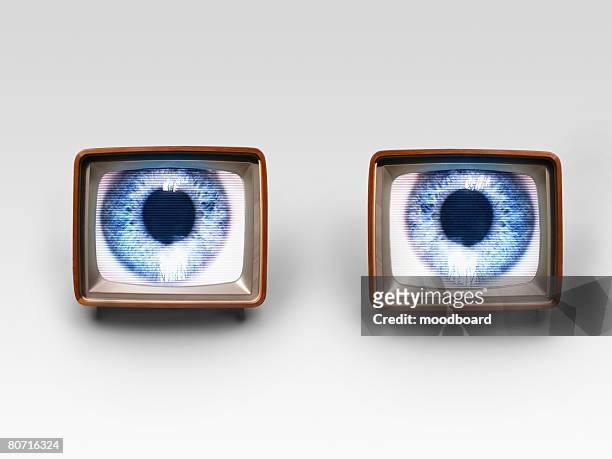 two old fashioned tv sets with blue eyes in studio shot - big brother imagens e fotografias de stock