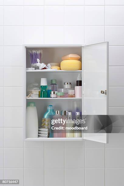 various cosmetics and bath products in bathroom cabinet - bathroom medicine cabinet stock pictures, royalty-free photos & images