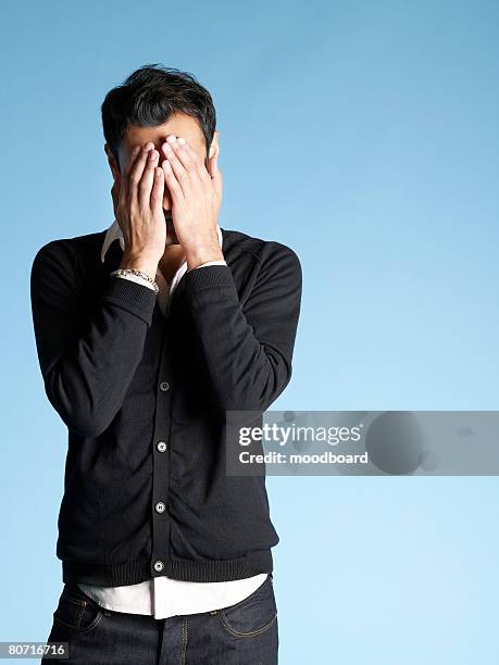 young man with head in hands - touching head stock pictures, royalty-free photos & images