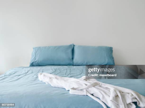 bathrobe on bed - bed comforter stock pictures, royalty-free photos & images