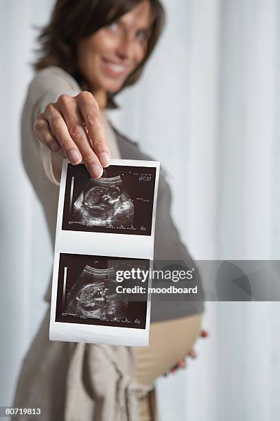 pregnant woman holding sonogram - ultra sonography stock pictures, royalty-free photos & images