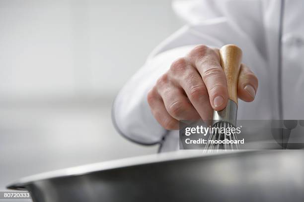 chef mixing ingredients in bowl close-up - schneebesen stock-fotos und bilder