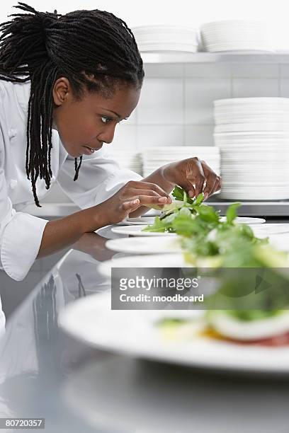 female chef preparing salad in kitchen - black chef stock pictures, royalty-free photos & images